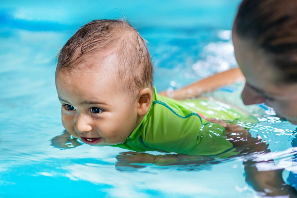 Mother with baby boy in the swimming pool on swimming class