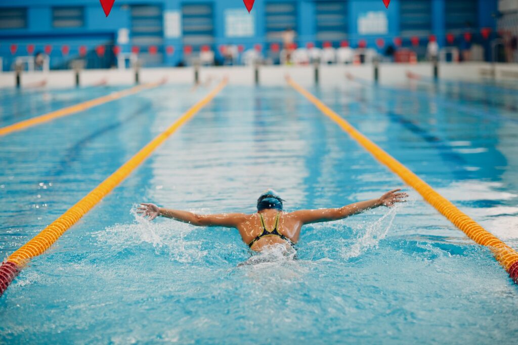 Young woman swimmer swims in swimming pool.